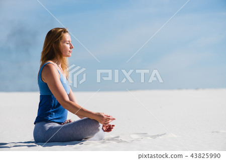 Woman relax in lotus yoga pose in desert 43825990