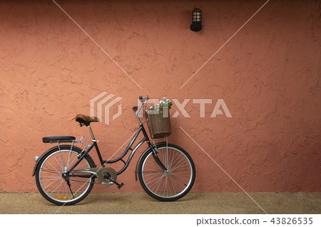 Vintage bicycle standing near the red brown wall Vintage bicycle standing near the red brown wall 43826535
