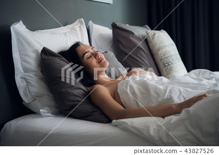 Good dreams make your day better. Attractive young woman sleeping joyfully Good dreams make your day better. Attractive young woman sleeping joyfully 43827526