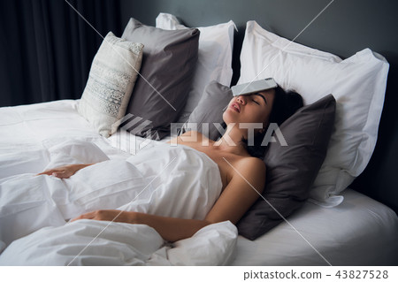 Women felt asleep with a mobile phone on her face at night In the bedroom at her house. She sleep 43827528