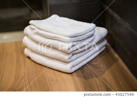 bathroom still-life, white towels on wooden table bathroom still-life, white towels on wooden table 43827540