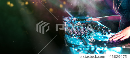 Dj mixes the track in the nightclub at a party Dj mixes the track in the nightclub at a party 43829475