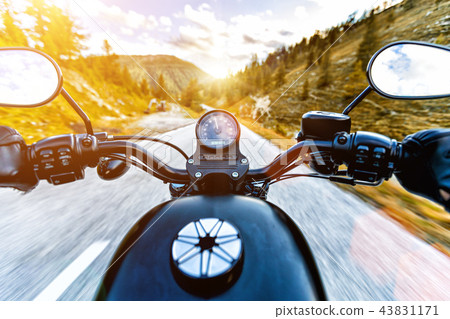 Motorcycle driver riding in Alpine highway, handlebars view, Austria, Europe. 43831171