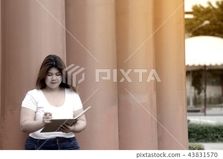 Pretty Asian fat women pose and thinking at a pole Pretty Asian fat women pose and thinking at a pole 43831570