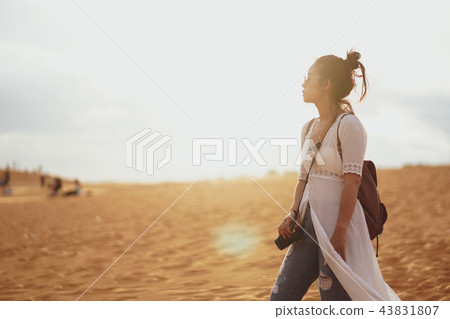 Woman exploring the desert, sandy beach with bag. Woman exploring the desert, sandy beach with bag. 43831807