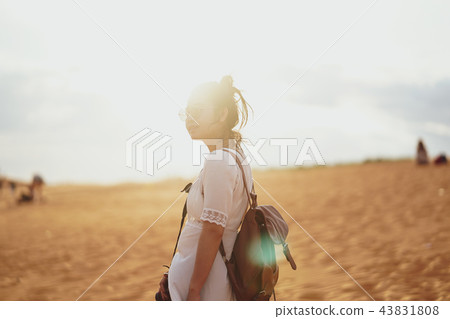 Woman exploring the desert, sandy beach with bag. Woman exploring the desert, sandy beach with bag. 43831808