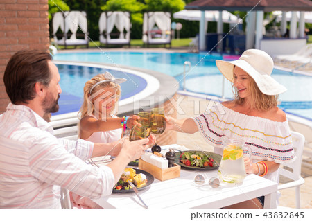 Delighted joyful happy family cheering with drinks 43832845
