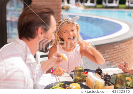 Delighted happy girl enjoying her delicious food Delighted happy girl enjoying her delicious food 43832870