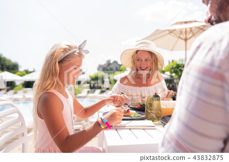 Joyful positive nice girl enjoying her meal Joyful positive nice girl enjoying her meal 43832875