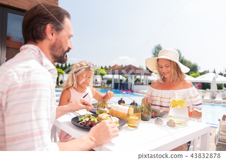 Joyful positive family having their meal together Joyful positive family having their meal together 43832878
