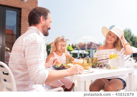 Delighted positive family sitting together at the table Delighted positive family sitting together at the table 43832879