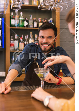 Handsome barman smiling and flirting with young visitor 43834214