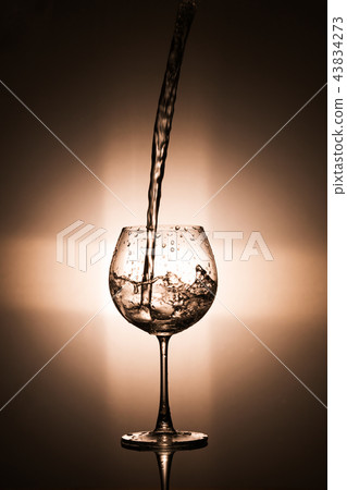 Pouring water in to the wine glass 43834273
