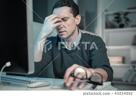 Frustrating man keeping eyes closed putting hand to face Frustrating man keeping eyes closed putting hand to face 43834892