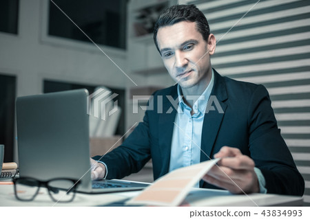 Concentrated professional man watching at papers with diagrams 43834993