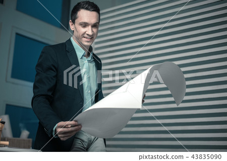 Pleasant thoughtful nice man holding a papers Pleasant thoughtful nice man holding a papers 43835090