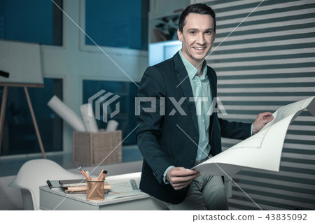 Smiling smart man exploring a drawings for project Smiling smart man exploring a drawings for project 43835092