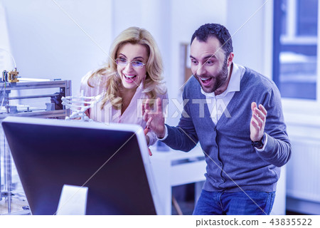 Joyful bearded man staring at screen of computer Joyful bearded man staring at screen of computer 43835522