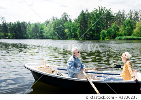 Peaceful pensioners enjoying the nature while rowing the boat Peaceful pensioners enjoying the nature while rowing the boat 43836233