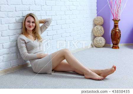 Young lovely woman in dress sitting on the floor and posing. Young lovely woman in dress sitting on the floor and posing. 43838435