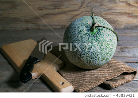 melon and knife on cutting board melon and knife on cutting board 43839421