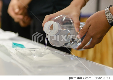 pouring normal saline into medical nursing set 43840944