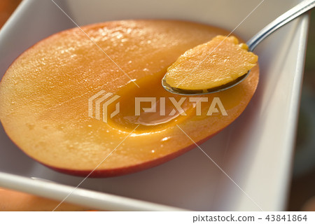 Spoon into a lonesome mango image 43841864