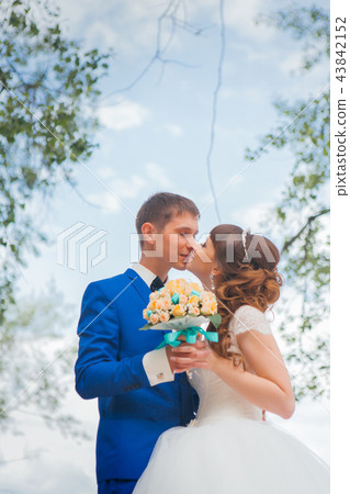 bride and groom kissing on the background of trees 43842152