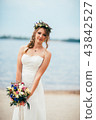 young bride with a bouquet of flowers standing  43842527