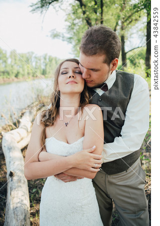 bride and groom standing arm in  against  43842559