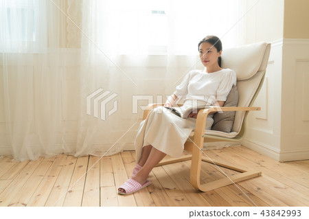 A woman sitting at a window A woman sitting at a window 43842993
