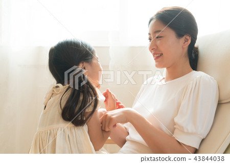 Mother and daughter sitting at the window 43844038