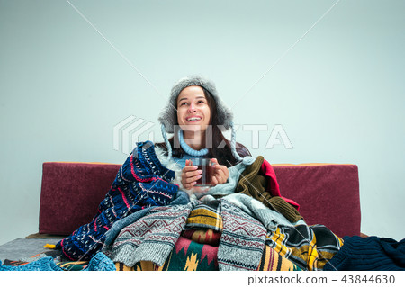 The young woman with Flue Sitting on Sofa at Home. Healthcare Concepts. 43844630