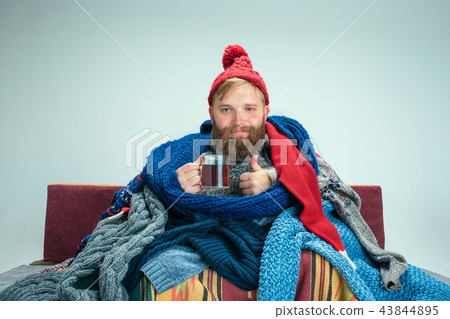 Bearded Man with Flue Sitting on Sofa at Home. Healthcare Concepts. 43844895