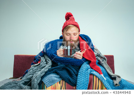 Bearded Man with Flue Sitting on Sofa at Home. Healthcare Concepts. 43844948