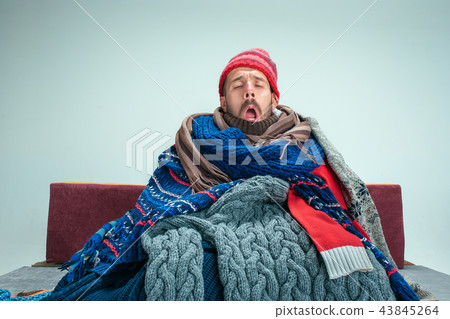Bearded Man with Flue Sitting on Sofa at Home. Healthcare Concepts. 43845264