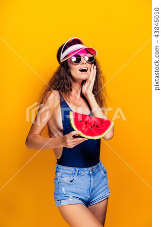 Woman in cap and swimwear hold slice of watermelon 43846010