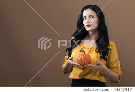 Young woman holding a pumpkin 43847417