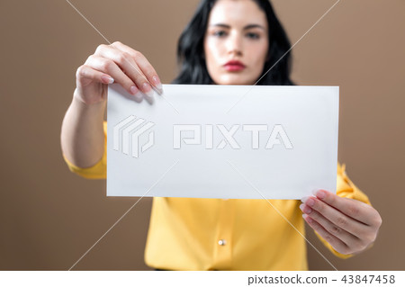Young woman holding up a blank sign 43847458
