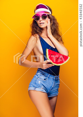 Woman in cap and swimwear hold slice of watermelon 43848582