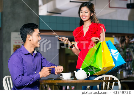 Happy young man waiting for his beautiful girlfriend after shopping Happy young man waiting for his beautiful girlfriend after shopping 43849728