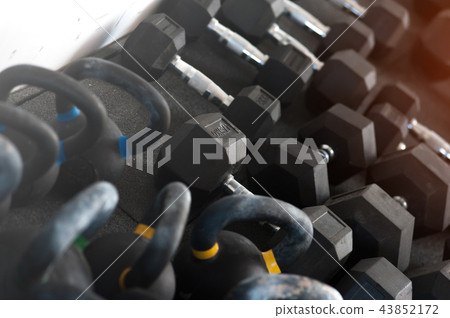 Different weights kettle bells and dumbbells on the floor 43852172
