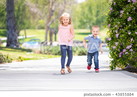 Sister and Brother Outdoors Waving American Flags Sister and Brother Outdoors Waving American Flags 43855884