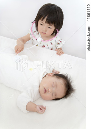 A young girl looks at a newborn baby with a toy stethoscope and imitating a doctor. Doctor play, dreams, future, goals A young girl looks at a newborn baby with a toy stethoscope and imitating a doctor. Doctor play, dreams, future, goals 43861550