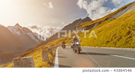 Motorcycle drivers riding in Alpine highway on famous Hochalpenstrasse, Austria, Europe. Motorcycle drivers riding in Alpine highway on famous Hochalpenstrasse, Austria, Europe. 43864546