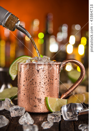 Cold Moscow Mules - Ginger Beer, lime and Vodka on bar 43864718