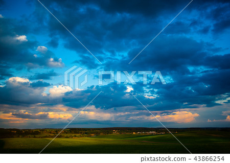 Dark blue clouds moving over green fields Dark blue clouds moving over green fields 43866254