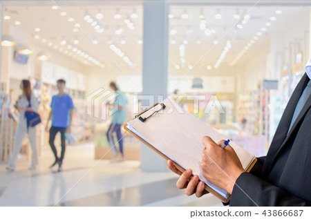 Businessman wearing suit writing on notepad Businessman wearing suit writing on notepad 43866687