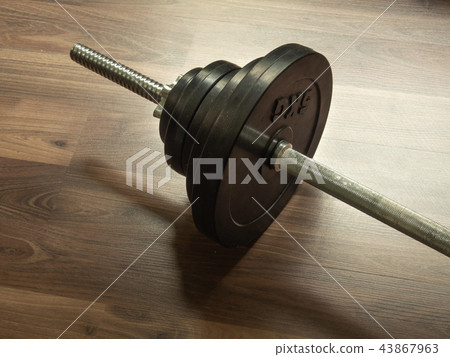 Dumbbell barbell on brown wood background. Dumbbell barbell on brown wood background. 43867963