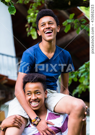 Boy carrying his friend on shoulder 43868283